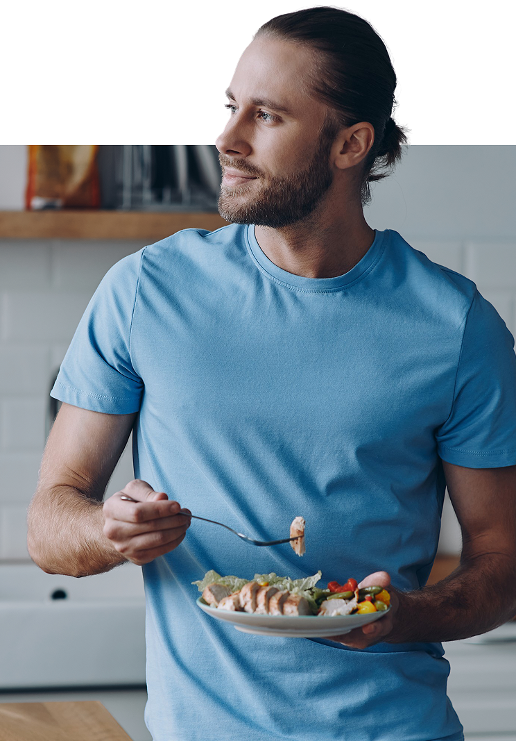 A fit man enjoying a fresh, macro-balanced ReBuilt meal with a satisfied smile